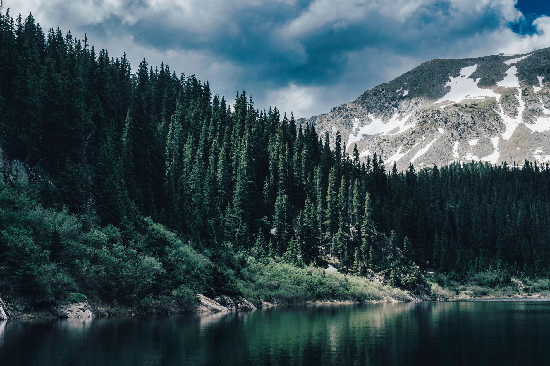 Mountain lake surrounded by evergreen forest in Colorado